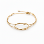 Aura Knot Bracelet — Gold delicate bracelet champagne gold-tone with knot detail on clean white background, product flat lay, ZARIÉ fine jewellery SÉRÉNITÉ collection