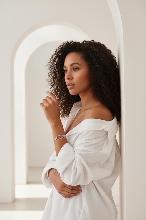 Aura Knot Bracelet — Silver delicate bracelet silver-tone with knot detail lifestyle shot worn on model against neutral background, ZARIÉ fine jewellery ÉLORA collection