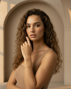 Bird Charm Bracelet – Gold delicate bracelet champagne gold-tone lifestyle shot worn on model against neutral background, ZARIÉ fine jewellery SÉRÉNITÉ collection