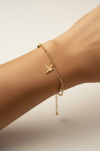Bird Charm Bracelet – Gold delicate bracelet champagne gold-tone lifestyle shot worn on model against neutral background, ZARIÉ fine jewellery SÉRÉNITÉ collection