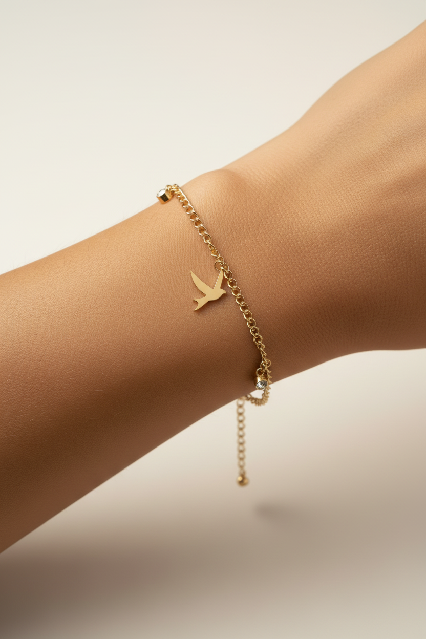 Bird Charm Bracelet – Gold delicate bracelet champagne gold-tone lifestyle shot worn on model against neutral background, ZARIÉ fine jewellery SÉRÉNITÉ collection
