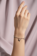 Bird Charm Bracelet- Silver delicate bracelet silver-tone lifestyle shot worn on model against neutral background, ZARIÉ fine jewellery ÉLORA collection