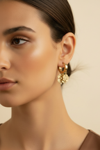 Clover Charm Hoop Earrings hoop earrings four-leaf clover motif lifestyle shot worn on model against neutral background, ZARIÉ fine jewellery SÉRÉNITÉ collection