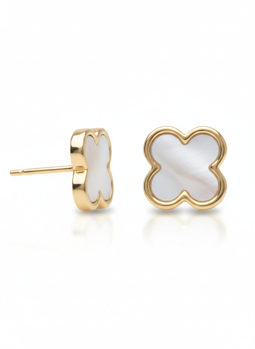 Pair of champagne gold four-leaf clover stud earrings with white mother-of-pearl clover-shaped inlay centres on clean white background, flat lay composition showing both earrings with butterfly back fastenings, polished metallic finish and refined minimal design for everyday wear