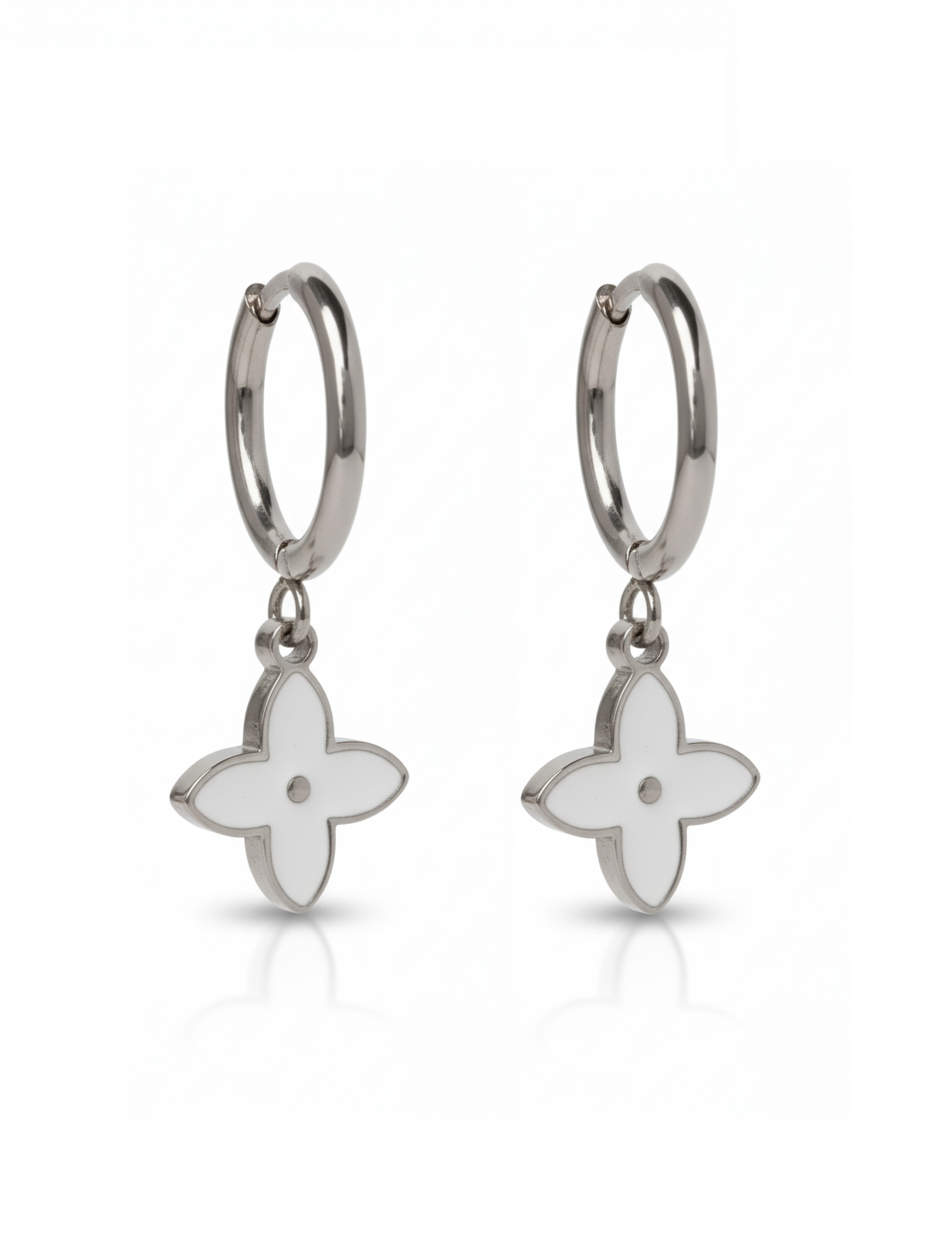Silver earrings with white flower-shaped charms on a white background