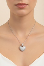 Heart Crest Necklace — Silver fine chain necklace silver-tone lifestyle shot worn on model against neutral background, ZARIÉ fine jewellery AMOURÉ collection