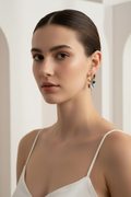 Woman wearing colorful earrings against a neutral background