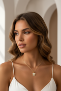 Petite Clover Necklace — Gold fine chain necklace champagne gold-tone four-leaf clover motif lifestyle shot worn on model against neutral background, ZARIÉ fine jewellery HARMONIE collection