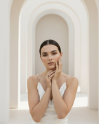 Red stone halo ring in champagne gold photographed on soft beige linen background, featuring red gemstone with crystal halo detailing, minimal elegant design with warm beige aesthetic and polished metallic finish