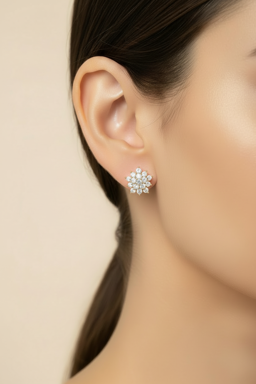 Close-up of a person wearing a floral silver earring against a beige background