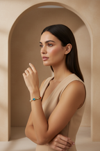 Woman wearing a beige dress and colorful bracelet in a beige archway