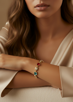 Close-up of a woman's arm wearing a bracelet with colorful gemstones, against a neutral background.
