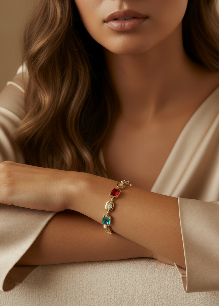 Close-up of a woman's arm wearing a bracelet with colorful gemstones, against a neutral background.