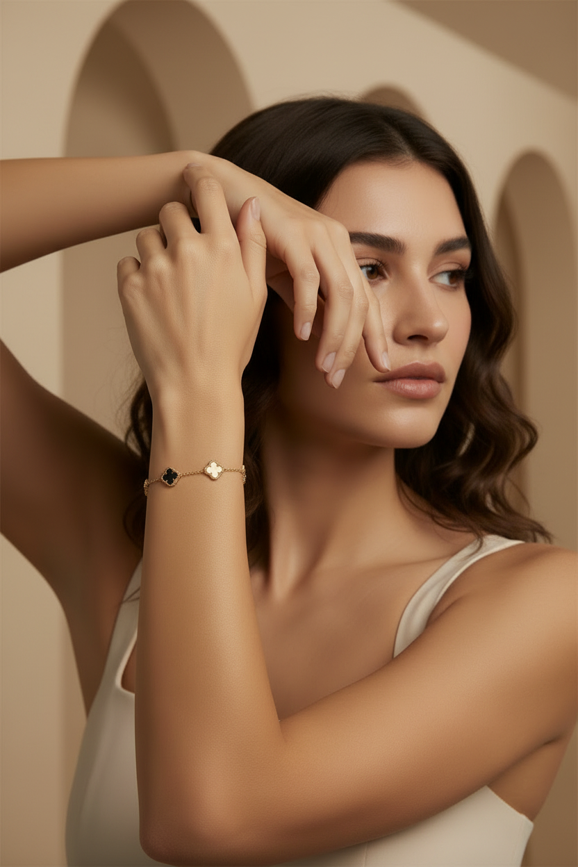 Woman wearing gold bracelets on a neutral background