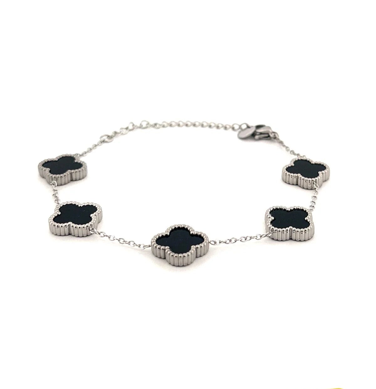 Silver bracelet with black clover-shaped charms on a white background