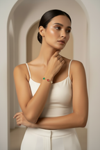 Woman wearing a white top and colorful bracelet in a neutral setting