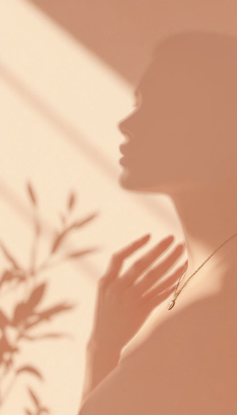 Silhouette of a person with a necklace against a warm-toned background
