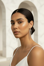 Woman wearing large  earrings with a neutral background