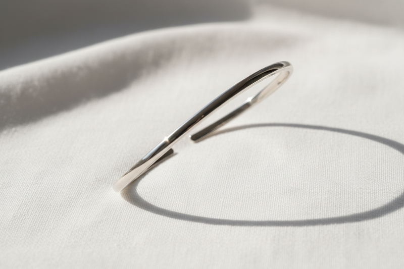Silver bracelet on a light fabric background